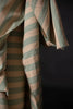 Striped fabric with green and beige colors on a dark background