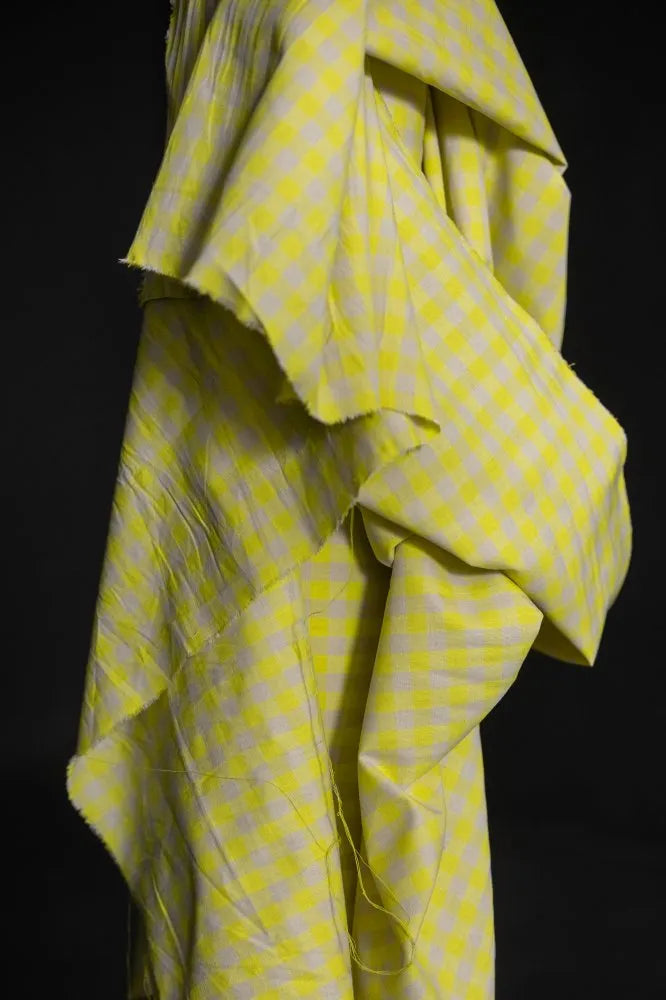 Yellow and white checkered fabric draped over a black background