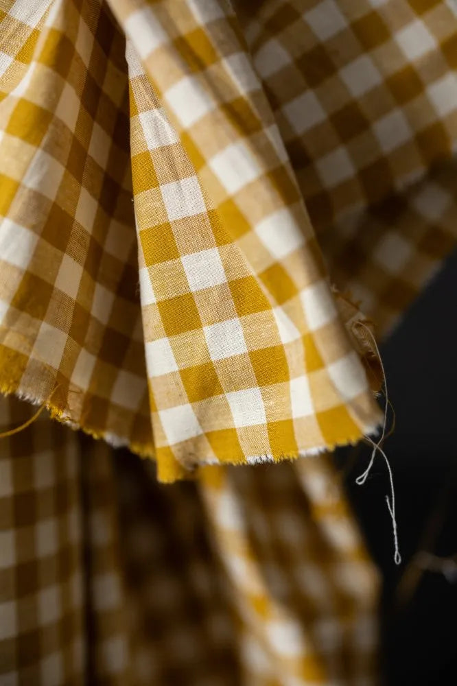 Close-up of yellow and white checkered fabric with a dark background