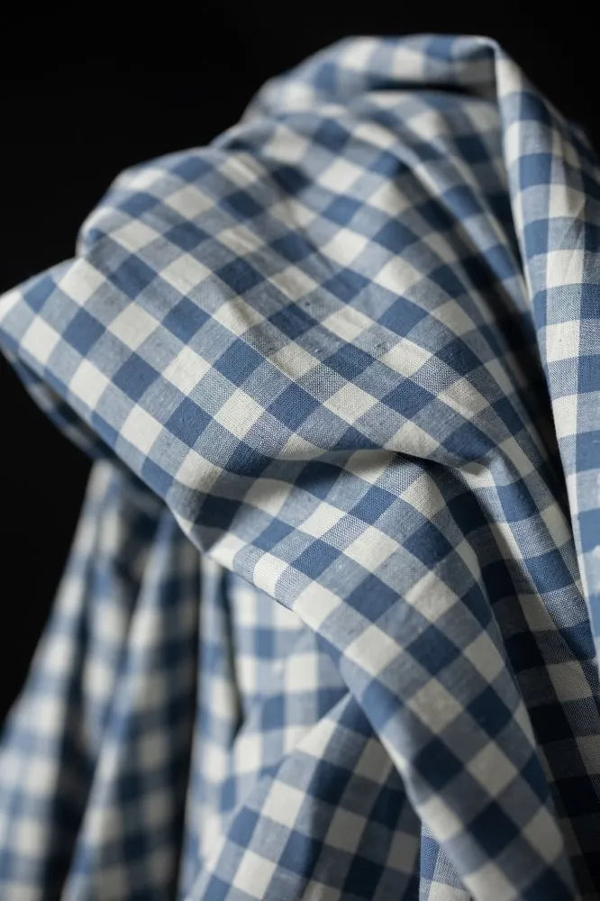 Close-up of blue and white checkered fabric against a black background