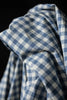Close-up of blue and white checkered fabric against a black background