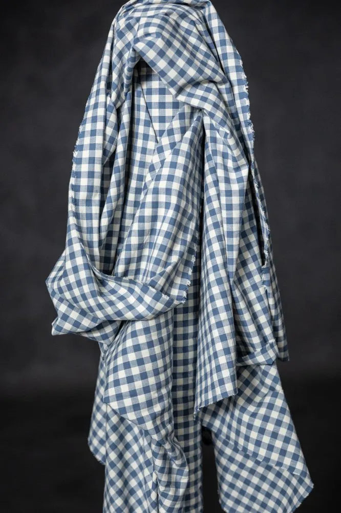 Blue and white checkered fabric draped over a black background