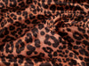 Close-up of leopard print fabric with brown and black spots.