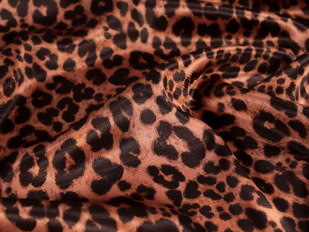 Close-up of leopard print fabric with brown and black spots.