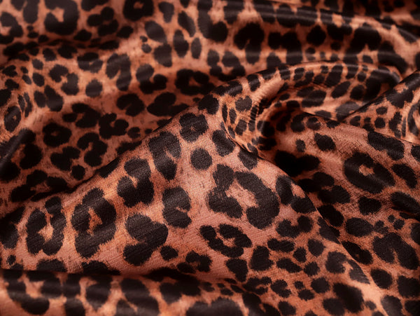 Close-up of leopard print fabric with brown and black spots.