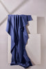 Blue fabric draped over a white geometric sculpture on a light gray background