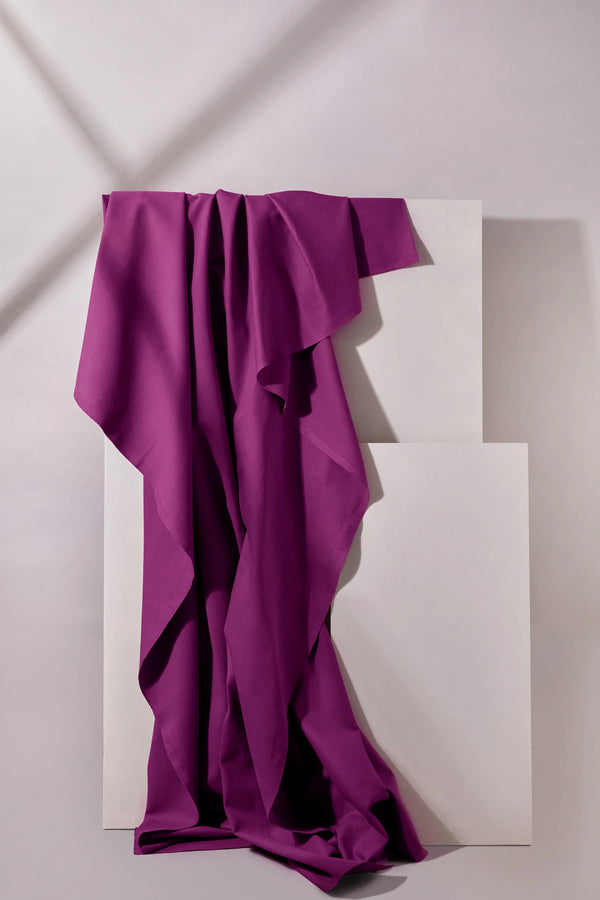 Purple fabric draped over a white geometric sculpture