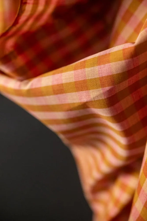 Close-up of a checkered fabric with orange and red patterns.