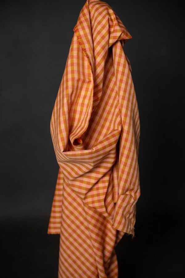 Orange and brown checkered fabric draped over a black background