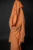 Orange and brown checkered fabric draped over a black background