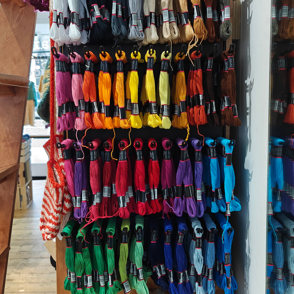 Colorful skeins of embroidery floss on display in a store.