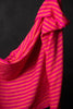A swatch of neon orange and fuchsia striped linen fabric against a black background.