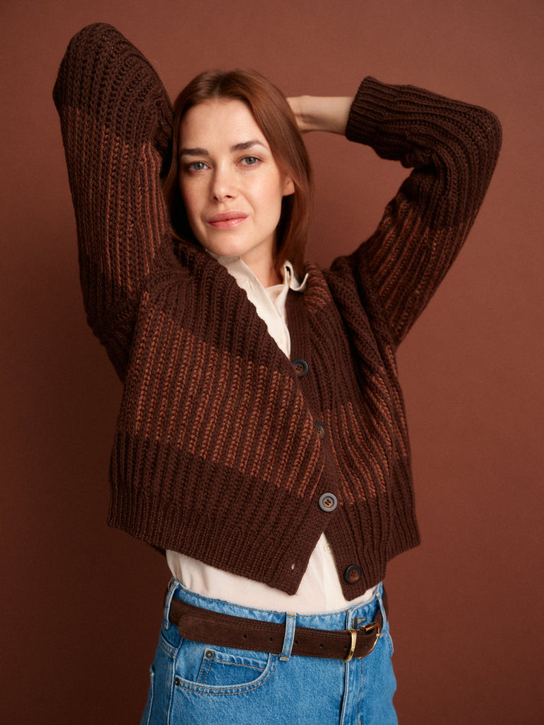 Woman wearing a brown knitted cardigan against a brown background