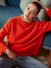 Person wearing a red sweater sitting on a blue couch.