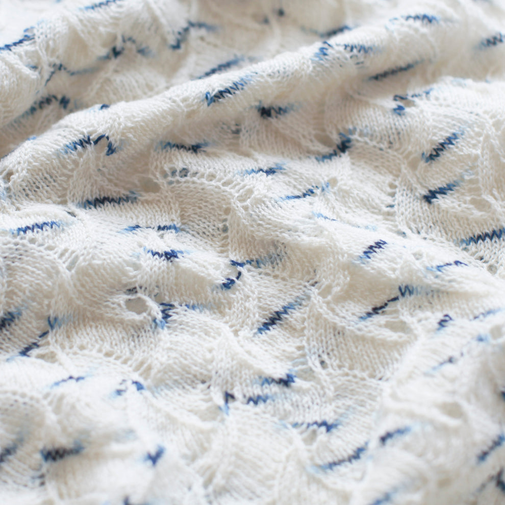 Close-up of textured white fabric with blue thread