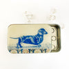 Tin box with a blue dachshund illustration on a white background