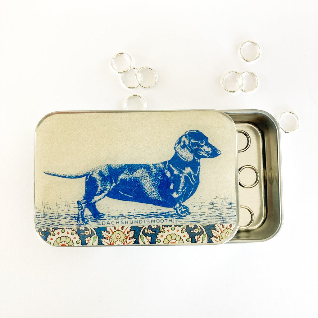 Tin box with a blue dachshund illustration on a white background