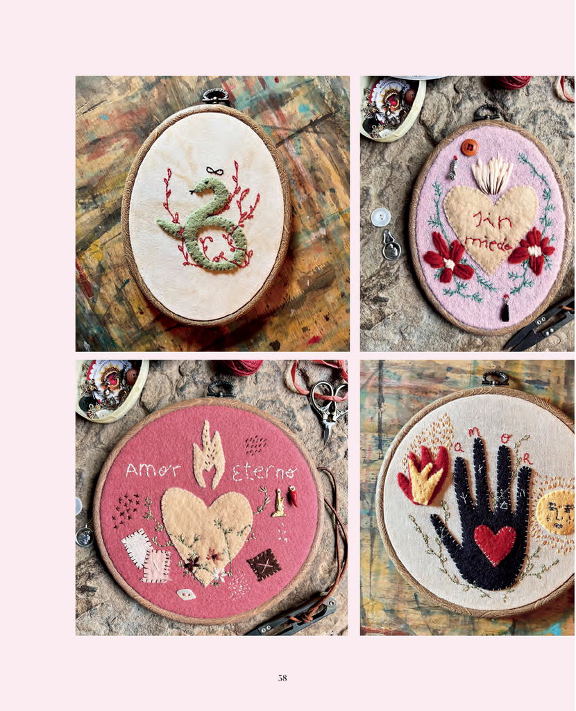 A collage of four oval and round embroidered art pieces displayed on a distressed painted wood surface, with small sewing tools around them. The designs include a green snake on cream, a pink heart with flowers and the words 'in love', a pink heart with 'amor eterno' on dusty pink, and a black hand with a red heart and small sun on cream.