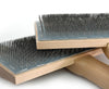 Two wooden brushes with dark metal pins, stacked diagonally on a clean white background.