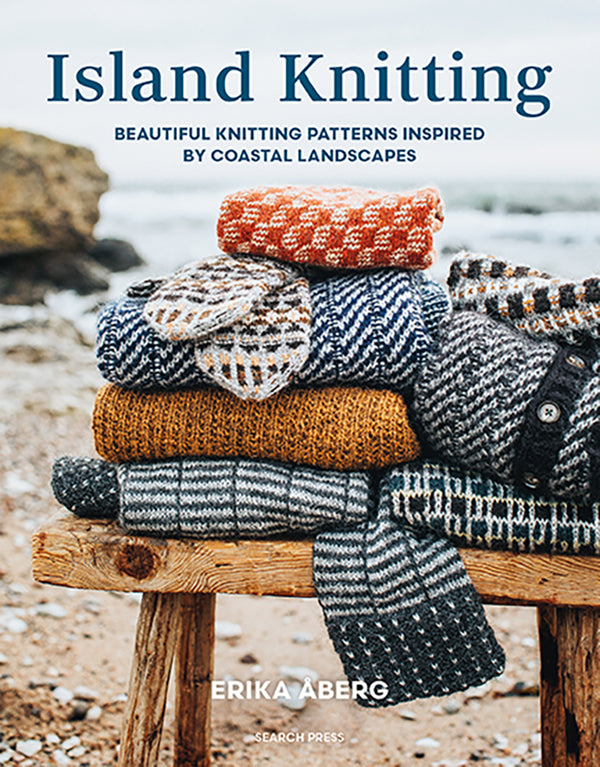 Book cover of 'Island Knitting' by Erika Aberg with knitted sweaters on a wooden stool by a beach.