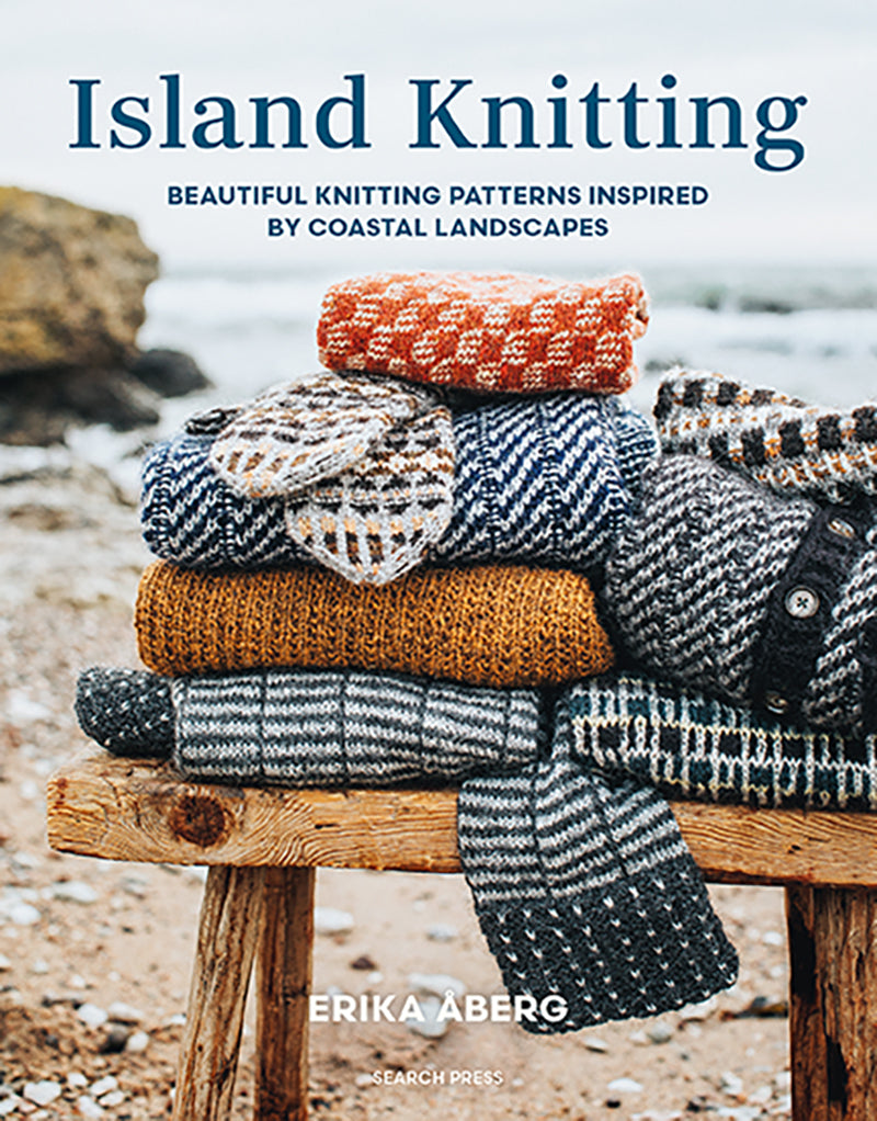 Book cover of 'Island Knitting' by Erika Aberg with knitted sweaters on a wooden stool by a beach.