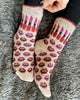Patterned socks being held on a textured gray surface