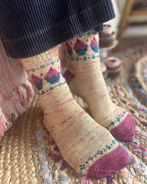 Close-up of feet wearing patterned socks on a textured rug.