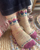 Close-up of feet wearing patterned socks on a textured rug.