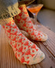 Person wearing patterned socks on a wooden surface with a blurred background