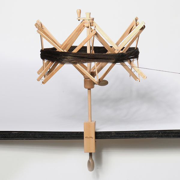 wooden umbrella swift with a hank of yarn on it.