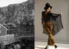Person holding a black lace shawl with a scenic coastal view on the left