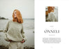 Woman wearing a sweater by a body of water with 'Onneli' branding.