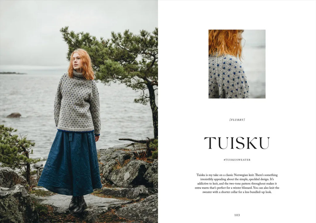 Woman wearing a patterned sweater and blue skirt standing by a lake with trees in the background.