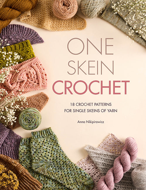 Book cover for 'One Skein Crochet' by Anna NiŁpirowicz, featuring a central cream background with the title in large gray and pink text, surrounded by styled crochet yarn balls, knitted swatches, and floral accents in soft earthy and pastel tones.