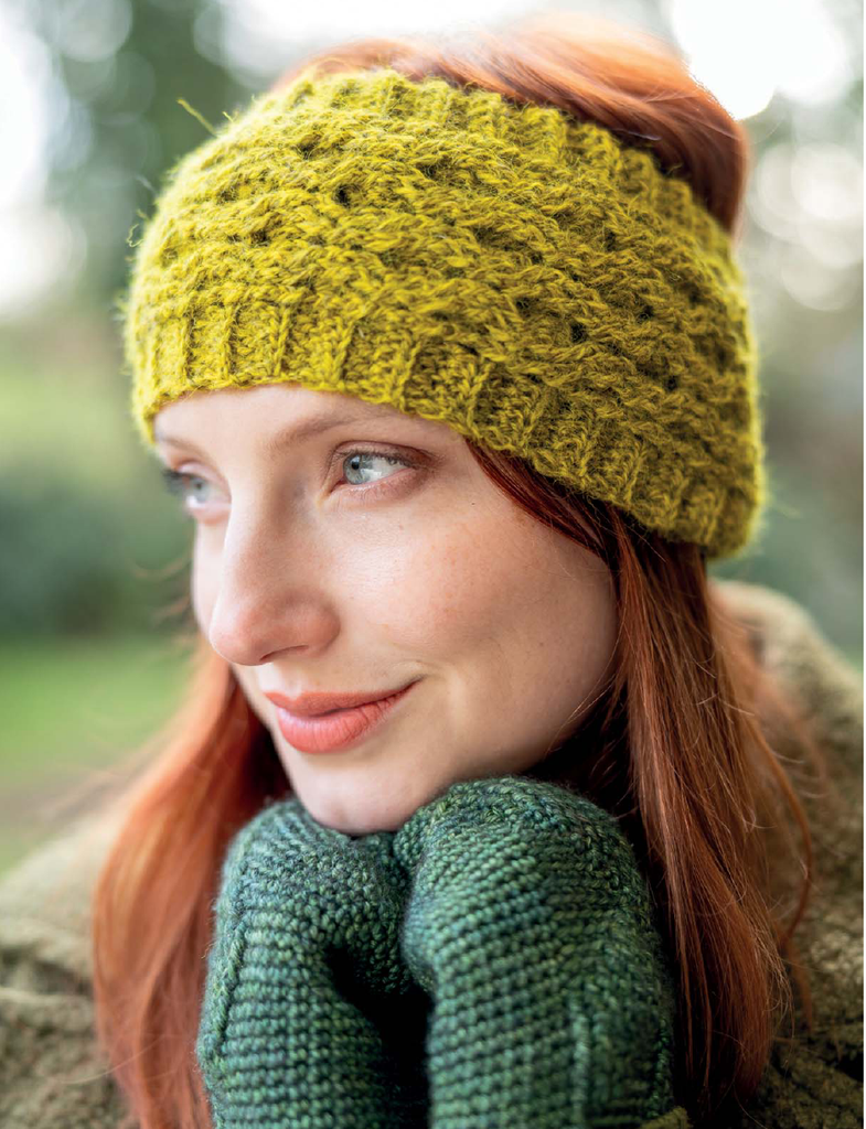 A close-up lifestyle shot of a woman wearing a textured olive green knit headband and matching green knit gloves, with her red hair visible.