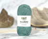 Teal skein of yarn with 'Knit Wanderer' label on a white background