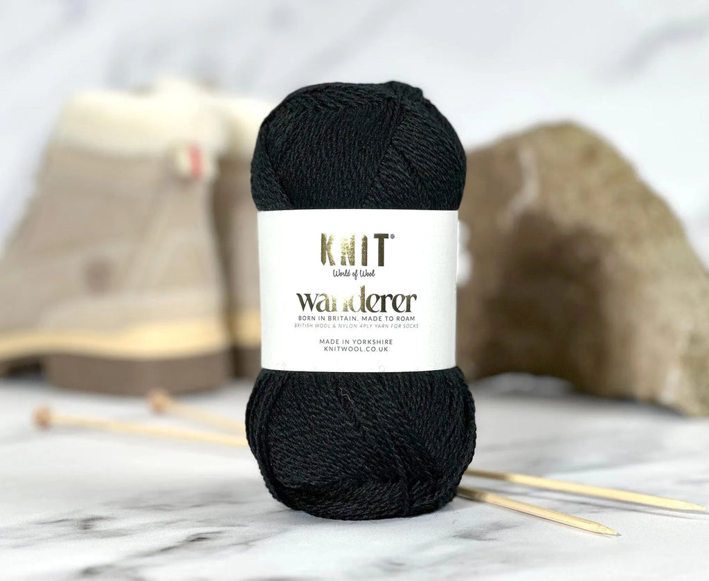 Black yarn ball with a label on a marble surface