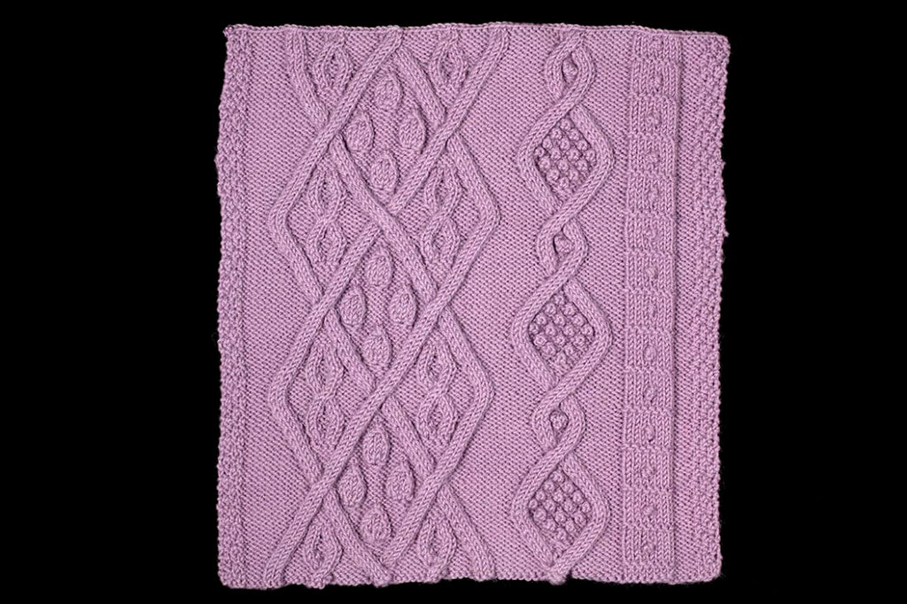 Purple knitted fabric with a diamond pattern on a white background
