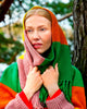 Person wearing a colorful scarf and sweater in a forest setting