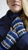 Person wearing blue and white patterned mittens with a blurred background