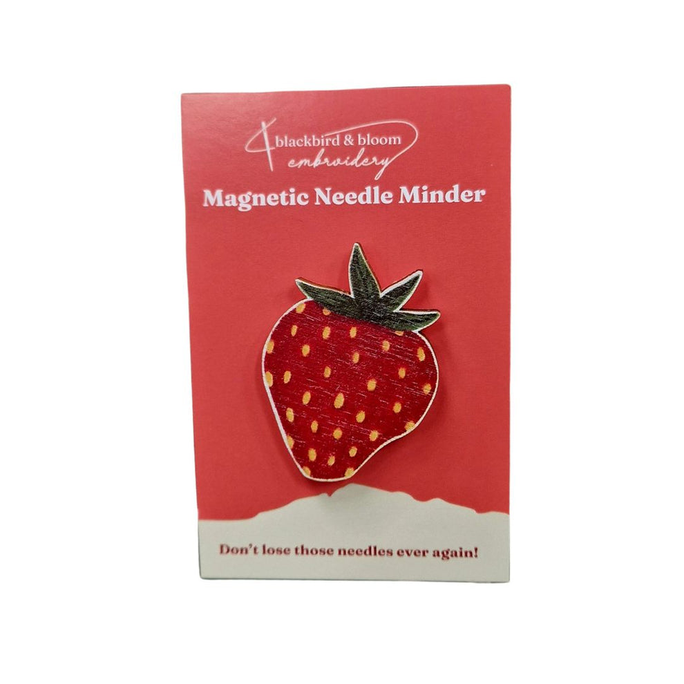 Strawberry-shaped magnetic needle minder on a red card with 'blackbird & bloom' branding.