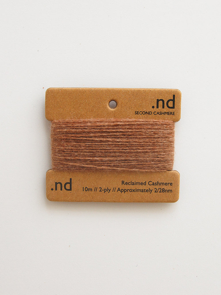 Two brown cashmere swatches on a beige card with 'nd' branding on a white background