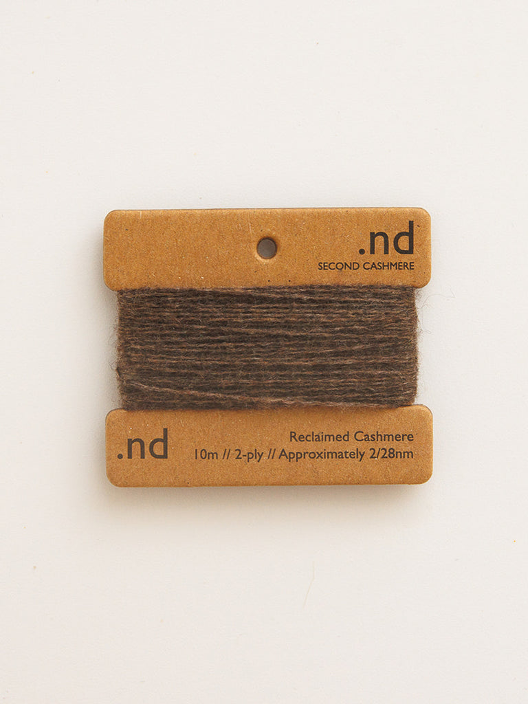 Reclaimed cashmere yarn on a branded card with 'nd' label on a beige background