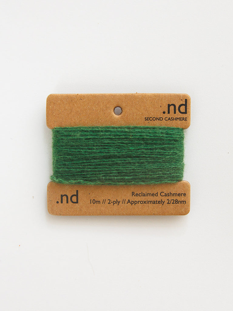 Green cashmere yarn on a brown card with 'nd' branding on a white background