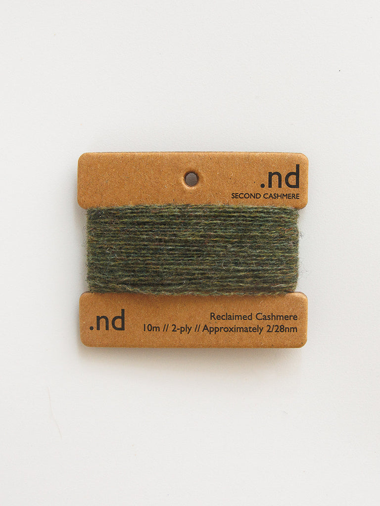 Green yarn on a brown card with 'nd' branding on a white background
