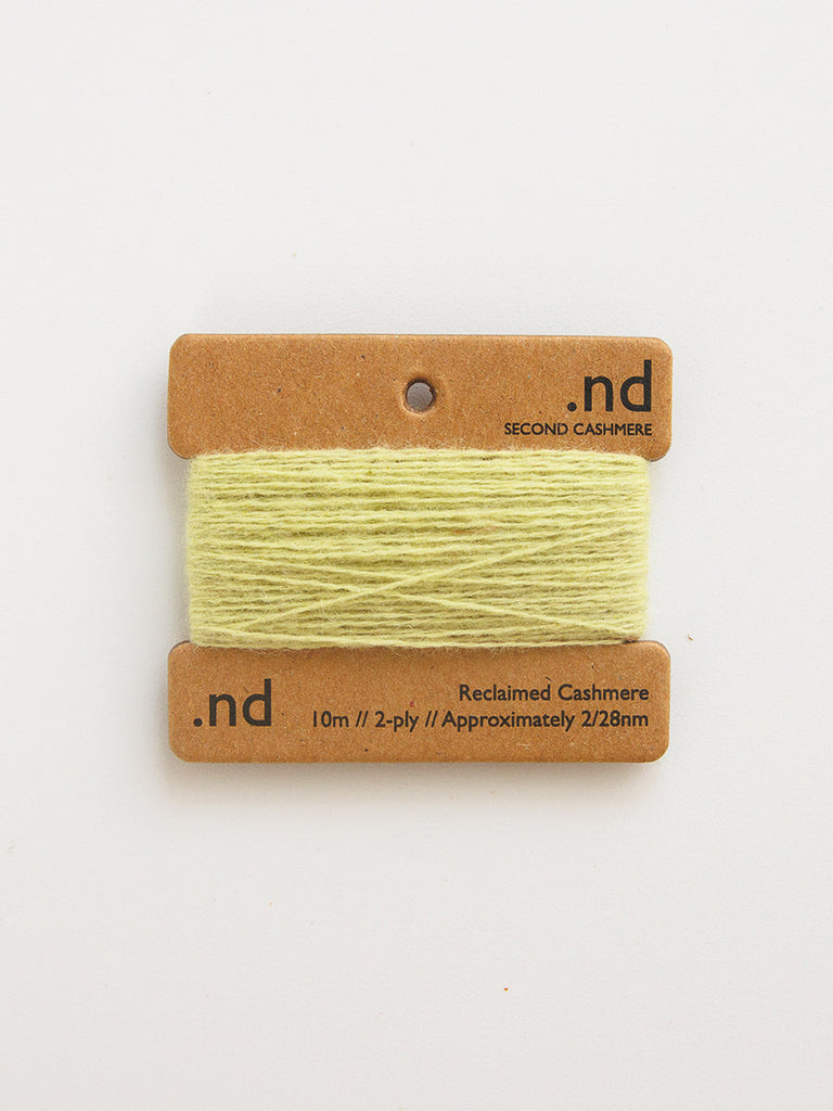 Light green yarn on a cardboard holder with 'nd' branding on a white background