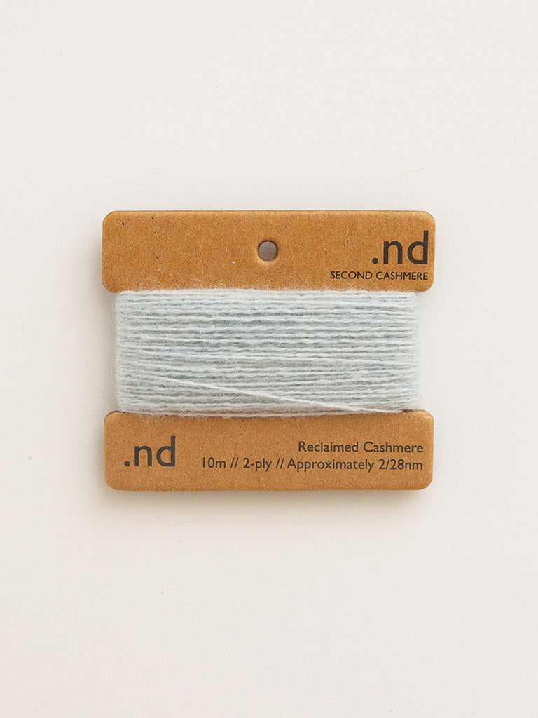 Reclaimed cashmere yarn on a branded card with 'nd' logo on a light background