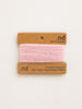 Pink yarn on a 'nd' branded card with product details on a white background