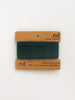 Green yarn swatch on a brown card with 'nd' branding on a white background