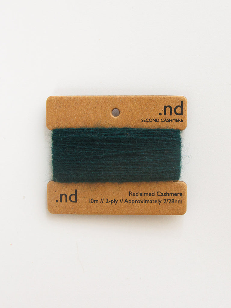 Green yarn swatch on a brown card with 'nd' branding on a white background
